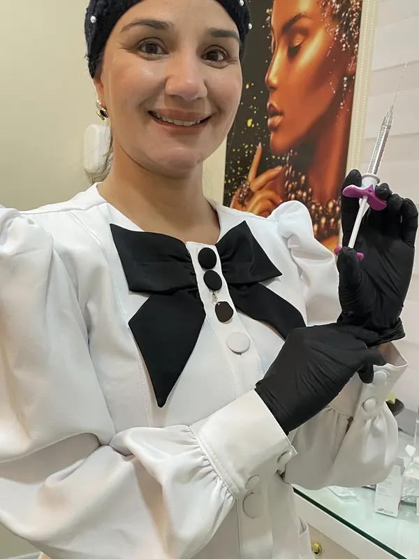 Dra. Érica Mello sorrindo no consultório antes de um atendimento