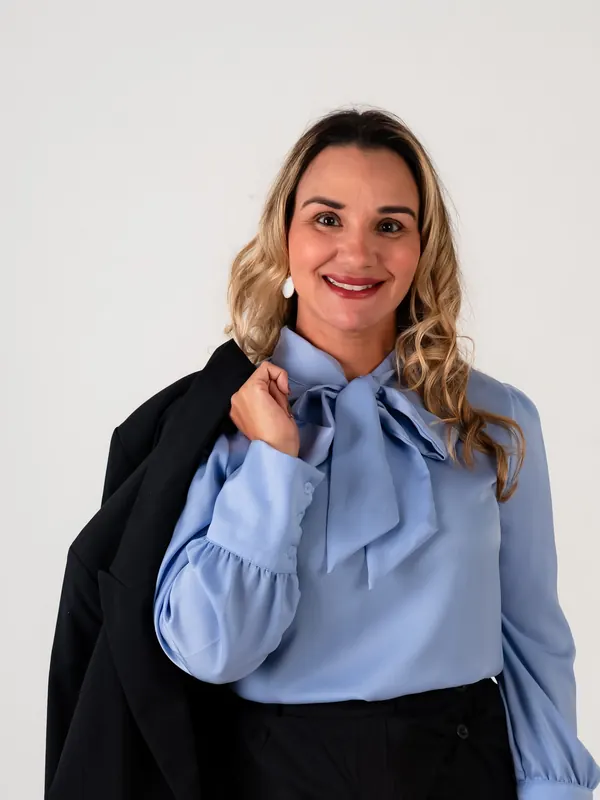 Dra. Érica Mello de blusa azul e blazer no ombro
