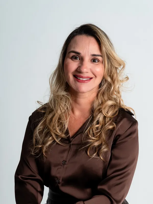 Dra. Érica Mello de blusa marrom, sentada