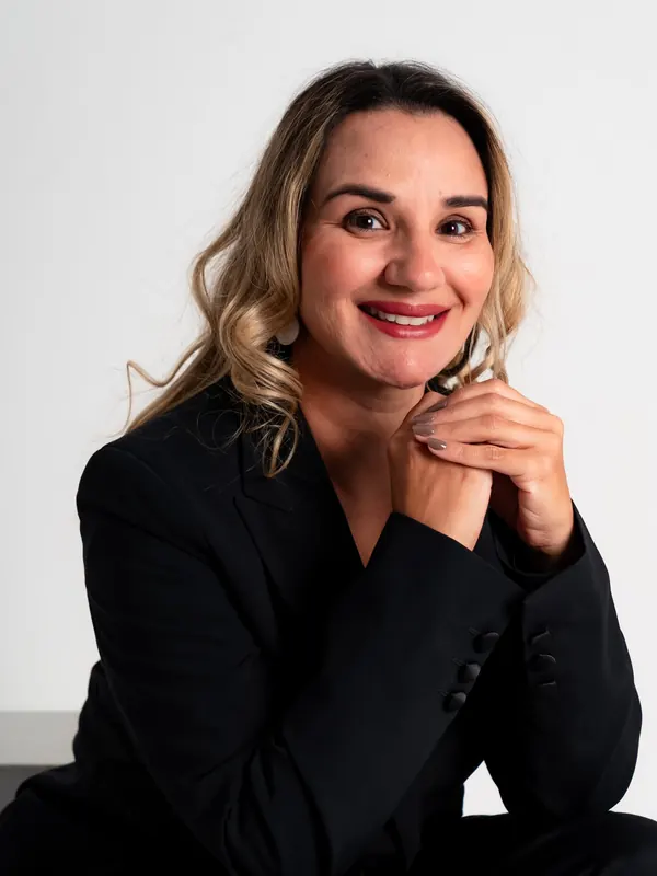 Dra. Érica Mello de blazer preto, sorrindo